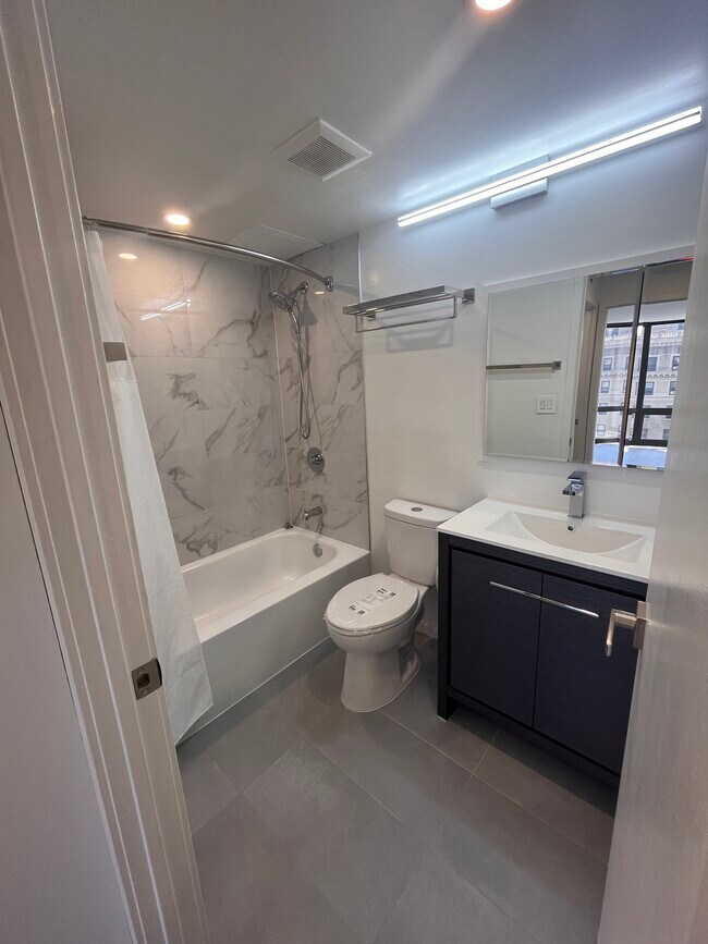 Bathroom remodeled in July 2023 with marble tub/shower surround, medicine cabinet, and slate floors. - 2020 Walnut St