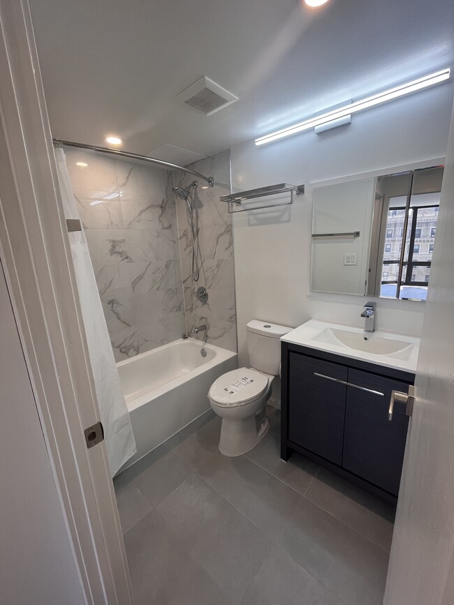 Bathroom remodeled in July 2023 with marble tub/shower surround, medicine cabinet, and slate floors. - 2020 Walnut St