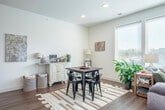 Located at 5265 University Ave in Madison, WI, this well-appointed 1-bedroom, 1-bathroom residence offers a thoughtfully designed open-concept layout filled with natural light. The living and dining area flows seamlessly from the kitchen, anchored by large windows and a sliding glass door that floods the space with sunlight and offers views of the surrounding cityscape. Warm hardwood-style flooring runs throughout, complementing the clean white walls and modern finishes.

The kitchen is equipped with stainless steel appliances, crisp white cabinetry with matte black hardware, and granite countertops that extend to a breakfast bar with pendant lighting overhead. The living area features a generous wall of windows, creating an airy, open ambiance ideal for both relaxing and entertaining.

The spacious bedroom provides a calm retreat with a window for natural light, ample room for furnishings, and direct access to a well-sized walk-in closet with full-length hanging rods and shelving. The bathroom continues the home's refined aesthetic with granite countertops, white cabinetry, and a wide vanity mirror with modern lighting. A connecting hallway ties all spaces together, completing this efficiently designed and stylish residence.