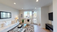 Located at 246 Cooley Lane in Santa Maria, California, this contemporary two-story home is designed with a clean, modern aesthetic throughout. The interior is characterized by light-toned walls, recessed lighting, and light wood-style flooring that flows consistently across both levels, creating a cohesive and airy atmosphere.

The main living area is open and welcoming, featuring large windows and a glass door that opens to a private balcony, framing views of neighboring palm trees and filling the space with abundant natural light. The adjoining dining area benefits from the same open layout and is anchored by a stylish pendant light fixture, while seamlessly connecting to the kitchen.

The kitchen is well-equipped with white cabinetry, stone countertops, stainless steel appliances including a gas range and built-in microwave, and a generous island with a double sink — offering both functionality and a bright, clean design.

The upper-level primary bedroom is notably spacious with tall ceilings, large windows, and direct balcony access. Additional bedrooms provide comfortable accommodations with their own natural light and exterior access. A full bathroom features a dual-sink vanity and a tub-shower combination. A dedicated laundry room with a full-size washer and dryer adds further practicality to this well-appointed home.