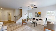 Located at 901 Porchlight Drive in Loganville, Georgia, this well-appointed two-story home offers three bedrooms, four bathrooms, and a thoughtfully designed layout spread across two floors. The main level sets a welcoming tone, beginning with a bright entryway adorned with crown molding that opens to a combined dining and living area. Light-toned hardwood-style flooring flows throughout the main level, complementing the neutral palette and ceiling fans that enhance the airy atmosphere. The kitchen is a standout feature, equipped with white shaker cabinetry extending to the ceiling, granite countertops, a classic subway tile backsplash, stainless steel appliances, and a window above the sink that brings in natural light. A staircase with wood treads and iron balusters connects the two floors with style. Upstairs, the more expansive floor hosts the three bedrooms, including a generously sized primary suite with a walk-in closet outfitted with wire shelving and plush carpeting. Additional bedrooms are carpeted and filled with natural light from well-placed windows offering views of surrounding greenery. A dedicated upstairs laundry room adds everyday convenience. With four full bathrooms distributed across both levels, this home delivers a practical and comfortable layout suited for modern living.