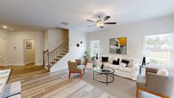 Located at 901 Porchlight Drive in Loganville, Georgia, this well-appointed two-story home offers three bedrooms, four bathrooms, and a thoughtfully designed layout spread across two floors. The main level sets a welcoming tone, beginning with a bright entryway adorned with crown molding that opens to a combined dining and living area. Light-toned hardwood-style flooring flows throughout the main level, complementing the neutral palette and ceiling fans that enhance the airy atmosphere. The kitchen is a standout feature, equipped with white shaker cabinetry extending to the ceiling, granite countertops, a classic subway tile backsplash, stainless steel appliances, and a window above the sink that brings in natural light. A staircase with wood treads and iron balusters connects the two floors with style. Upstairs, the more expansive floor hosts the three bedrooms, including a generously sized primary suite with a walk-in closet outfitted with wire shelving and plush carpeting. Additional bedrooms are carpeted and filled with natural light from well-placed windows offering views of surrounding greenery. A dedicated upstairs laundry room adds everyday convenience. With four full bathrooms distributed across both levels, this home delivers a practical and comfortable layout suited for modern living.