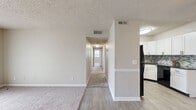 Located at 700 Airways Circle in Nashville, TN, this single-floor, 2-bedroom, 2-bathroom home offers a well-planned layout designed for comfortable everyday living. The living room is a welcoming, open space finished with plush carpeting and a sliding glass door that fills the room with natural light and provides direct access to an outdoor area. A central hallway with wood-look flooring connects the living spaces to the private quarters, with the kitchen conveniently positioned off the entry. The kitchen is a standout feature, showcasing white shaker-style cabinetry extending to the ceiling, dark granite countertops, a mosaic tile backsplash, and a full suite of black appliances, all set atop light wood-look flooring. The spacious primary bedroom offers generous proportions, plush carpet, a ceiling fan, a window with outdoor views, and a closet with built-in shelving. The second bedroom is similarly carpeted and offers a bright, flexible space. Both bathrooms are finished with wood-look flooring, white vanity cabinetry, and tub-shower combinations. A textured ceiling is consistent throughout, lending a cohesive character to the entire home.