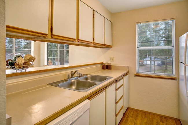 A kitchen with a window overlooking the property, lots of counter space, and plenty of cabinet storage space - Heron View