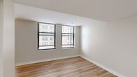 Located at 902 N Market St in the heart of Wilmington, DE, this one-bedroom, one-bathroom residence offers a well-designed single-floor layout with a clean, modern aesthetic throughout. Light-toned hardwood flooring runs continuously across all rooms, creating a cohesive and bright atmosphere.

The living area is open and airy, with natural light filtering in through large windows dressed with blinds that frame views of the surrounding urban cityscape. The space flows seamlessly toward the kitchen and bedroom areas, giving the unit a sense of openness despite its efficient footprint.

The kitchen is fully equipped with stainless steel appliances including a range, built-in microwave, dishwasher, and refrigerator. Light wood cabinetry pairs with granite-style countertops to create a functional and attractive cooking space with ample storage.

The bedroom is a comfortable, well-proportioned retreat featuring large corner windows that invite generous natural light and urban views. Neutral walls and the same hardwood flooring maintain a calm, consistent design.

The bathroom includes a full soaking tub with shower combination in a clean, all-white surround. A dedicated laundry area with in-unit hookups adds everyday convenience. A hallway closet provides additional storage. The overall ambiance is modern, neutral, and move-in ready.