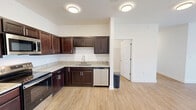 Located at 1023 Center View Rd in Sevierville, Tennessee, this single-floor, three-bedroom, two-bathroom home offers a clean, modern design with a cohesive aesthetic throughout. Light wood-tone flooring runs seamlessly across all rooms, complementing the crisp white walls and creating a bright, welcoming atmosphere.

The kitchen is a standout feature, equipped with rich dark-espresso cabinetry, granite-look countertops, and a full suite of stainless steel appliances including a range, microwave, refrigerator, and dishwasher. It opens toward the living area, making it well-suited for everyday functionality. The combined kitchen and living room area provides a comfortable, open space for daily living.

Each of the three bedrooms is finished with the same warm wood flooring and neutral white walls. The primary bedroom is a generously sized retreat, while the additional bedrooms offer ample space. Several bedrooms feature ceiling fans with light fixtures and large windows fitted with blinds, allowing natural light and outdoor views of the surrounding neighborhood.

The two bathrooms are finished with matching dark cabinetry, granite-top vanities, and brushed nickel fixtures. One bathroom includes a tub-shower combination with white tile surround. Two closets provide practical storage throughout the home. The overall design is clean, functional, and move-in ready.