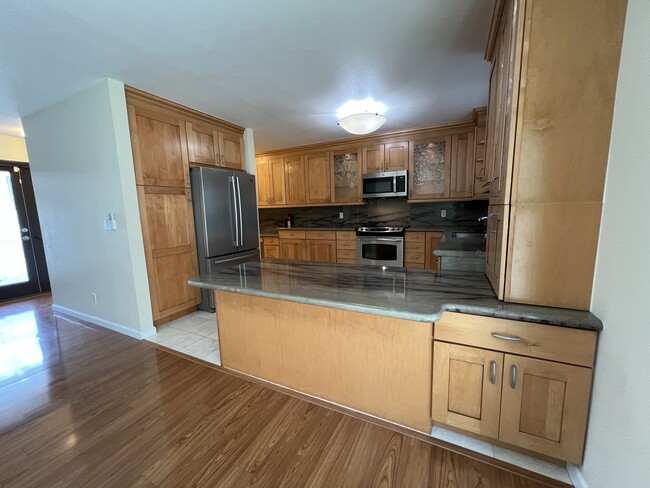 Large Kitchen with Stainless Steel appliances, custom glass lighted cabinetry, granite counters. - 742 Hoawa St
