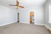 This well-organized one-bedroom, one-bathroom unit in Twin Falls, Idaho, offers an efficient and functional layout across a single floor. The generous bedroom is a standout feature, providing ample room for furnishings and comfort. It is finished with plush carpeting, crown molding, a textured ceiling, and a ceiling fan with integrated lighting. Multiple white-paneled doors lead to closets and the adjoining bathroom, while a pair of windows allows for natural light to fill the space. The bathroom is finished with dark hardwood-style flooring and textured gray walls, featuring a walk-in shower with chrome fixtures, a sink, and a separate toilet area. The compact kitchen is equipped with white appliances, including an electric range and a full-size refrigerator, complemented by natural wood cabinetry and light-toned flooring. A ventilation hood above the range adds practicality, and a window brings in additional natural light. The entrance area, accessible via a paneled white door, connects seamlessly to the rest of the unit, with additional closet storage nearby. Throughout the unit, baseboard heating provides consistent warmth, and a neutral gray and white color palette lends a clean, cohesive aesthetic to the space.