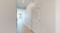 Located at 675 9th Ave in San Diego's vibrant Little Italy neighborhood, this modern 2-bedroom, 2-bathroom residence is designed with clean lines and a contemporary aesthetic. Light wood flooring flows throughout the open-concept layout, complemented by crisp white walls and abundant natural light.

The kitchen-living area serves as the heart of the home, featuring a striking granite waterfall island with pendant lighting, floor-to-ceiling windows, and sleek cabinetry extending to the ceiling. Stainless steel appliances, including a gas range and French door refrigerator, and a subway tile backsplash complete the chef-inspired kitchen.

Both bedrooms are bright and airy, with floor-to-ceiling sliding glass doors opening to a balcony that frames sweeping San Diego skyline views. Exposed concrete architectural accents add an industrial touch to the modern design.

The two bathrooms are well-appointed with large-format tile, one featuring a glass-enclosed shower and the other a soaking tub with elegant stone tile surround and brushed gold fixtures. A welcoming entry hallway with louvered closet doors and recessed lighting transitions smoothly into the main living areas. Two closets and dedicated storage provide excellent functionality throughout this thoughtfully designed urban residence.