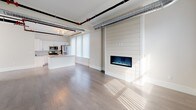 This thoughtfully designed single-floor unit blends modern finishes with industrial character in a striking and functional layout. The open-concept living and dining area is defined by rich hardwood flooring, large windows that invite abundant natural light, and a standout shiplap accent wall framing a built-in electric fireplace. Exposed silver HVAC ductwork and black piping trace the ceiling throughout, lending the space a contemporary loft-inspired aesthetic.

The kitchen is well-appointed with white cabinetry, granite countertops, a classic subway tile backsplash, and a full suite of stainless steel appliances including a gas range, microwave, and refrigerator. A kitchen island with additional counter space adds both functionality and flow to the layout.

The bedroom features plush wall-to-wall carpeting, exposed overhead piping consistent with the industrial design theme, and direct access to a generously sized walk-in closet with built-in shelving. The bathroom is finished with large-format tile flooring, a granite-topped gray vanity with ample storage, a wide mirror with overhead lighting, and dual heated towel racks for added comfort. A walk-in shower completes the bathroom's clean, modern look. Overall, the space offers a cohesive blend of warmth, practicality, and urban style.