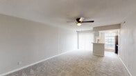 This single-story 1-bedroom, 1-bathroom residence offers a thoughtfully designed layout that maximizes functionality and comfort. The open living area is bright and welcoming, featuring soft wall-to-wall carpeting, a textured ceiling, and a ceiling fan with a built-in light fixture. Large sliding glass doors dressed with vertical blinds flood the space with natural light and provide easy access to the outdoors. A peninsular breakfast bar seamlessly connects the living area to the kitchen, creating an open, sociable flow between the two spaces. The kitchen is well-equipped with white cabinetry accented by gold hardware, subway tile backsplash, light countertops, a double stainless steel sink with a matte black faucet, and black appliances including a refrigerator and range. Light wood-look flooring and a window overlooking the exterior complete the kitchen's clean, modern aesthetic. The bedroom is generously sized with plush carpeting, a ceiling fan, a natural light-admitting window, and a reach-in closet with dual hanging rods. Panel-style interior doors with dark hardware add a refined touch throughout. The unit also features an electrical panel conveniently located within the bedroom area.