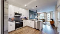 This thoughtfully designed one-bedroom, one-bathroom residence in Northglenn, Colorado offers a modern and cohesive living experience across a single floor. The open-concept layout seamlessly connects the kitchen and living room, creating an inviting, functional space filled with natural light. The kitchen features white shaker-style cabinetry, dark quartz countertops, a grey tile backsplash, stainless steel appliances including a full-size refrigerator and dishwasher, and warm wood-look flooring that flows throughout the main living areas. Sleek pendant lighting adds a contemporary touch overhead. The living room is anchored by a teal accent wall and offers direct access to a private balcony, bringing in an abundance of natural light and outdoor views. The bedroom is a calm retreat, highlighted by a large window with exterior views, plush carpet, and a coordinating teal accent wall. The full bathroom is well-appointed with white shaker cabinetry, a dark quartz vanity, wood-look flooring, and a full soaking tub with tiled surround. A dedicated walk-in closet and a separate in-unit laundry room with full-size washer and dryer round out this residence's practical and comfortable amenities.