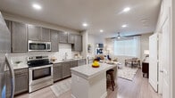 Located at 11918 Clay Road in Houston, TX, this one-bedroom, one-bathroom residence offers a thoughtfully designed open-concept floor plan that maximizes every square foot. The kitchen serves as the heart of the home, boasting grey shaker-style cabinetry, a white subway tile backsplash, granite-topped counters, a full suite of stainless steel appliances, and a central island with bar seating — ideal for both cooking and casual dining. Light wood-style flooring runs throughout, lending a clean, cohesive aesthetic. The kitchen flows seamlessly into the living area, which is brightened by a large window dressed with sheer curtains and fitted with a ceiling fan for year-round comfort. The bedroom is a comfortable retreat featuring a generous window that allows ample natural light, a ceiling fan, and easy access to a dedicated closet with built-in shelving for organized storage. The full bathroom is finished with white subway tile surrounding the soaking tub and shower combination, complemented by wood-look flooring and clean, neutral tones. Recessed lighting throughout enhances the bright, modern ambiance of this efficient and stylish Houston residence.