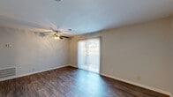 This 2-bedroom, 2-bathroom single-floor home in Roanoke, Virginia offers a practical and well-appointed layout. The living room serves as the heart of the space, featuring rich dark hardwood-style flooring, a ceiling fan with light fixture, and sliding glass doors fitted with vertical blinds that invite natural light and provide access to an outdoor area. The kitchen is outfitted with crisp white shaker-style cabinetry, dark countertops, and a full suite of black appliances including a range, microwave, refrigerator, and dishwasher. A dedicated in-unit washer and dryer area is conveniently located within the kitchen space. The two bedrooms are carpeted for comfort — the primary bedroom includes a ceiling fan and closet access, while the secondary bedroom offers a window with blinds for natural light. Both bathrooms are functional and clean, with one featuring a tub-shower combination. A hallway and closet round out the layout, contributing to efficient use of space throughout. Neutral wall tones and consistent flooring choices create a cohesive, move-in-ready aesthetic throughout this Roanoke residence.