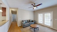 Located at 3220 Hoffmeyer Rd in Florence, SC, this well-appointed 2-bedroom, 2-bathroom single-story home offers a thoughtfully designed layout across a comfortable footprint. The living room features crown molding, a ceiling fan, and plush carpeting, with French doors that open to an outdoor area, filling the space with natural light. Adjacent to the living room, the dining area showcases hardwood-style flooring, elegant crown molding, and a multi-bulb chandelier that adds a warm, inviting atmosphere. The kitchen is designed with an open pass-through layout, granite-style countertops, rich wood cabinetry, black appliances including a refrigerator and range, and pendant lighting that enhances both function and style. The spacious primary bedroom includes a ceiling fan with light, plush carpeting, and a window for natural light. The second bedroom is equally comfortable, also featuring a ceiling fan and a window with exterior views. Both bathrooms are well-equipped with wood vanities, white countertops, and full tub-shower combinations with hardwood-style flooring. A dedicated laundry room houses a full-size washer and dryer alongside additional cabinetry for storage. Crown molding and neutral tones throughout lend the home a cohesive, polished feel.