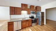 This single-floor, two-bedroom, two-bathroom residence offers a thoughtfully designed layout that balances comfort and functionality. Warm hardwood-style flooring flows consistently throughout the living areas and bedrooms, lending a cohesive, polished look to the entire space.

The kitchen is well-equipped with rich wood cabinetry, granite countertops, a stainless steel refrigerator, range, microwave, and dishwasher, providing ample storage and a practical workspace for everyday cooking.

Both bedrooms are generously sized and feature large windows that frame sweeping outdoor views, filling the rooms with abundant natural light. One bedroom includes a spacious walk-in closet outfitted with wire shelving and hanging rods for organized storage, while the second bedroom offers built-in shelving through an open closet.

The two bathrooms are finished with consistent, neutral-toned tile work and dark wood vanities topped with granite countertops. The primary bathroom features a glass-enclosed walk-in shower, while the second bathroom offers a full soaking tub with a tiled surround and curved shower rod. Recessed lighting and chrome fixtures complete each bathroom with a clean, modern aesthetic throughout.