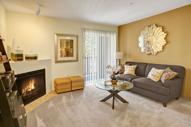 Living room with couch, coffee table, fireplace, and sliding glass door leading out to the balcony - Allegro