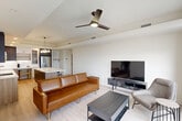 Located at 3100 Lake Villa Dr in Metairie, Louisiana, this thoughtfully designed one-bedroom, one-bathroom residence offers a contemporary open-concept layout that maximizes every square foot. Light-toned hardwood flooring flows throughout, unifying the living, dining, and kitchen areas into a seamless, airy space.

The designer kitchen is a standout feature, showcasing a large quartz waterfall island with seating for multiple guests, a mix of charcoal and warm wood cabinetry with gold hardware, and a full suite of stainless steel appliances. A sculptural multi-globe pendant light anchors the space with a modern artistic touch. A built-in desk nook adds versatile functionality.

The living area is bright and open, with large black-framed windows and a sliding door providing outdoor views and natural light, complemented by a sleek ceiling fan overhead. The bedroom continues the modern aesthetic with expansive windows, outdoor access, and generous closet space.

The bathroom features marble-look tile flooring, a walk-in glass shower, a wood vanity with quartz countertop, and a round black-framed mirror, delivering a clean, spa-like atmosphere. A dedicated laundry area with a full-size washer and dryer adds everyday convenience. The overall ambiance is polished, modern, and move-in ready.