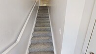 Located at 828 Westway Street in Elizabeth City, NC, this two-story home offers 2 bedrooms and 2 bathrooms across a well-organized layout. The main level hosts the primary living spaces, including a spacious living room featuring a fireplace, an elegant chandelier, and large windows that fill the room with natural light. Plush carpet flooring extends throughout the living and bedroom areas, adding warmth and comfort. The kitchen is equipped with warm oak cabinetry, light countertops, a coil-top range, refrigerator, and dishwasher, complemented by a window over the sink and a nearby pantry for additional storage. Both bathrooms feature wood-toned vanities and tub-shower combinations with clean, simple finishes. Each bedroom includes a double-door closet and a window offering natural light, with the primary bedroom providing a comfortable, private retreat. A carpeted staircase with white railings connects the floors, and the home also includes a utility room, hallway, and an impressive six closets throughout, ensuring generous storage. The overall aesthetic is clean and neutral, offering a move-in-ready canvas in a residential Elizabeth City neighborhood.