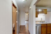 Located at 1570 Hunt Dr in Normal, IL, this two-story home offers 2 bedrooms and 2 bathrooms spread evenly across two floors of well-utilized living space. The main level features a bright living room with wood-look flooring, a ceiling fan, a striking full-height brick fireplace, and a sliding glass door that opens directly to a private patio. The kitchen is equipped with warm oak cabinetry, granite-look countertops, stainless steel appliances including a gas range and refrigerator, and a dishwasher. A hallway connects the kitchen to a full bathroom and leads into the open living area. The main floor also includes a dedicated laundry room and utility room for added convenience. Upstairs, the generously sized primary bedroom features plush carpeting, a ceiling fan, and multiple closets including a walk-in with wire shelving. The second bedroom also features carpeting, a ceiling fan, and a window for natural light. A second full bathroom with a wood vanity and large mirror serves the upper level. Four closets throughout the home provide ample storage. An attached garage with a wide concrete driveway completes this practical and comfortable two-story home.