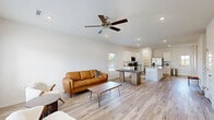 Located at 1423 Honeysuckle St in Lowell, Arkansas, this two-story home offers a well-designed layout across two floors, with the main level comprising the majority of the living space. The open-concept main floor seamlessly connects the living room and kitchen, creating a bright and airy atmosphere enhanced by recessed lighting, ceiling fans, and large windows that invite natural light. Light wood-tone flooring runs throughout the home, contributing to a clean, contemporary aesthetic with neutral white walls.

The living room is a comfortable gathering space featuring a ceiling fan and multiple windows with outdoor views. The kitchen is equipped with white shaker cabinets, granite countertops, stainless steel appliances including a French door refrigerator, and a walk-in pantry with built-in shelving. A dedicated laundry room houses a full-size washer and dryer with overhead shelving for added storage.

The home includes three bedrooms, with the generously sized primary bedroom offering a ceiling fan and its own en-suite bathroom featuring granite countertops, white cabinetry, a large mirror, and a glass-enclosed shower. Additional bathrooms include a tub-shower combo. The second floor provides additional bedroom space. A dedicated closet and multiple hallways round out the functional floor plan.