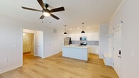 Located at 6600 Man O War Blvd in Lexington, KY, this efficiently designed single-floor home offers a thoughtful layout with modern finishes throughout. Light hardwood flooring flows seamlessly across the main living areas, complemented by neutral tones and clean white trim that give the space a bright, cohesive feel.

The open-concept kitchen and living room serve as the heart of the home. The kitchen is well-appointed with white shaker cabinetry, a striking quartz-topped island featuring shiplap paneling and an undermount sink, stainless steel appliances, and a subtle tile backsplash. Stylish pendant lights and recessed lighting illuminate the space, while a ceiling fan enhances comfort in the connected living area. A glass-paned door in the living room brings in natural light and provides outdoor access.

The generously sized primary bedroom features crown molding, a ceiling fan, and easy access to a built-in entry nook with hooks for storage. The bathroom is finished with white cabinetry, quartz countertops, brushed nickel hardware, and a large mirror with pendant lighting. A dedicated laundry area includes a full-size GE washer and dryer with overhead wire shelving. The attached single-car garage provides additional utility and convenience. The exterior features manicured landscaping and open surroundings.