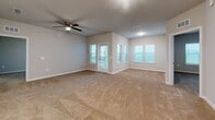 Located at 9940 Mahaffey Dr in Palmetto, FL, this 2-bedroom, 2-bathroom residence offers a thoughtfully designed single-floor layout with modern finishes throughout. The open-concept kitchen and living area serves as the heart of the home, featuring rich dark-espresso cabinetry, crisp white countertops, stainless steel appliances including a range and built-in microwave, and light wood-look flooring. A kitchen island with an integrated sink provides additional prep space and seating potential. The two bedrooms are carpeted for comfort and feature ceiling fans, neutral-toned walls, and windows that invite natural light. The primary bedroom is generously sized, with access to a well-appointed en-suite bathroom. This primary bathroom showcases a glass-enclosed walk-in shower with floor-to-ceiling tile, a white vanity with a sleek countertop, and wood-look flooring. The second bathroom mirrors the same clean aesthetic, offering a white vanity, a large mirror, and wood-look flooring. Additional spaces include a hallway, a utility room, and a closet, ensuring practical storage and functionality. The overall ambiance is clean, contemporary, and move-in ready.