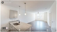 Located in Durham, NC, this thoughtfully designed one-bedroom, one-bathroom residence offers a comfortable and modern living experience across a single floor. The open-concept kitchen and living area serves as the heart of the home, where wood-look plank flooring, neutral white walls, and ceiling fan lighting create a bright, welcoming atmosphere. Natural light filters in through windows fitted with blinds, adding warmth to the living space.

The kitchen is a standout feature, showcasing granite countertops, gray shaker-style cabinetry, a suite of stainless steel appliances including a range, microwave, and refrigerator, and a sleek stainless wall-mount range hood. A peninsula with pendant lighting and an undermount sink doubles as a functional breakfast bar, seamlessly connecting the kitchen to the living area.

The bedroom offers plush wall-to-wall carpeting, a ceiling fan, and direct access to both the bathroom and a closet. The bathroom is clean and functional, featuring a tub-shower combination with subway tile surround, wood-look flooring, and built-in shelving for storage.

A dedicated in-unit laundry area houses a full-size top-load washer and dryer with overhead wire shelving, providing everyday convenience. The overall design balances modern finishes with practical functionality throughout.