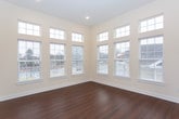 Located at 562 Washington Ave in Dumont, NJ, this single-floor residence offers a thoughtfully designed open layout with modern finishes throughout. The kitchen is a standout feature, showcasing rich dark cabinetry, crisp white countertops, stainless steel appliances including a gas range, built-in microwave, dishwasher, and refrigerator, all complemented by warm hardwood flooring and a movable center island. The adjacent living area is bathed in natural light, courtesy of an expansive bank of gridded windows that soar toward a raised ceiling, creating an airy, open atmosphere. The bedrooms feature soft wall-to-wall carpeting and generous windows with views to the outside, providing comfortable, light-filled retreats. The primary bathroom is well-equipped with dark wood vanity cabinetry, a white countertop, and a spacious glass-enclosed shower with tiled walls and neutral-toned floor tiles. A second full bathroom mirrors the same refined aesthetic with a matching vanity and accessible grab bars. A dedicated in-unit laundry closet with a full-size washer and dryer adds everyday convenience. Throughout the residence, a neutral color palette and consistent high-quality finishes create a clean, cohesive, and inviting living environment.