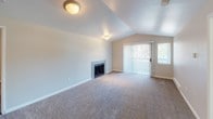 Located at 6248 S 242nd Pl in Kent, Washington, this single-floor residence at unit 15-302 offers a thoughtfully designed layout with a variety of functional spaces. The living room serves as a central highlight, featuring vaulted ceilings that create an open, airy atmosphere, soft carpeted flooring, a tile-surround fireplace, and a sliding glass door with vertical blinds that invites natural light and provides outdoor access. The entryway opens to a clear sightline of both the living and kitchen areas, with durable wood-look flooring grounding the transition zones. The galley-style kitchen is well-equipped with white shaker cabinetry, granite-look countertops, stainless steel appliances including a refrigerator, electric range, and dishwasher, complemented by wood-look plank flooring throughout. The unit includes multiple bedrooms, each carpeted and featuring windows with horizontal blinds that provide natural light and outdoor views, along with baseboard heating. The bathroom includes a granite-topped vanity with white cabinetry, a full tub-shower combination with tiled surround, and wood-look flooring. Clean neutral tones are carried throughout the unit, giving the space a cohesive and move-in ready feel.