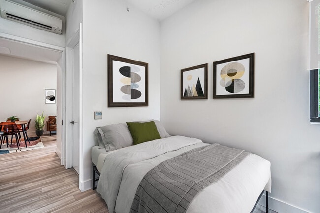 Dormitorio privado con cama matrimonial, escritorio, silla de oficina, armario, baño privado. - Plum Apartments