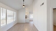Located in Glendale, Arizona, this single-story, four-bedroom, one-bathroom home offers a clean, modern aesthetic with thoughtful updates throughout. The open living area features vaulted ceilings that lend a sense of spaciousness, light wood-look flooring, and a striking dark tile-surround fireplace as a focal point. A large window allows natural light to fill the room, while a ceiling fan adds comfort. The kitchen is well-appointed with white shaker cabinetry, quartz countertops, a blue-gray subway tile backsplash, and a full suite of stainless steel appliances including a range, microwave, dishwasher, and refrigerator. A peninsula provides additional counter space and casual seating. Each of the four bedrooms features light wood-look flooring, neutral white walls, and windows with blinds that offer natural light and outdoor views. The primary bedroom includes a ceiling fan and ample closet space with sliding doors. Additional bedrooms are bright and versatile. The bathroom is clean and functional, featuring a tub-shower combination, wood-look flooring, and a vanity. Throughout the home, a consistent use of light tones and modern finishes creates a cohesive, move-in-ready environment.