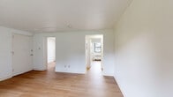 Located at 469 Livingston Ave in Albany, NY, this single-floor, two-bedroom unit offers a practical and well-organized layout. Light hardwood flooring runs consistently throughout the space, creating a cohesive and clean aesthetic from room to room.

The kitchen is efficiently designed with warm wood cabinetry, white appliances including a gas range and refrigerator, a built-in microwave, and a tiled backsplash. A window above the sink provides natural light, while a radiator ensures reliable heating. An entry door in the kitchen offers convenient access.

The living room is a bright, open space featuring light-filled windows with views of the surrounding greenery and a radiator for warmth. The clean white walls and wood flooring give the room a simple, airy quality.

Both bedrooms are well-sized and share a consistent design: white walls, light wood flooring, crown molding, and ceiling fans with integrated lighting. The primary bedroom benefits from natural light through a window with outdoor views, while both rooms offer a calm, comfortable atmosphere.

A hallway connects the rooms, contributing to the unit's efficient and straightforward flow. Overall, the space presents a clean, move-in ready environment with consistent finishes and functional features throughout.
