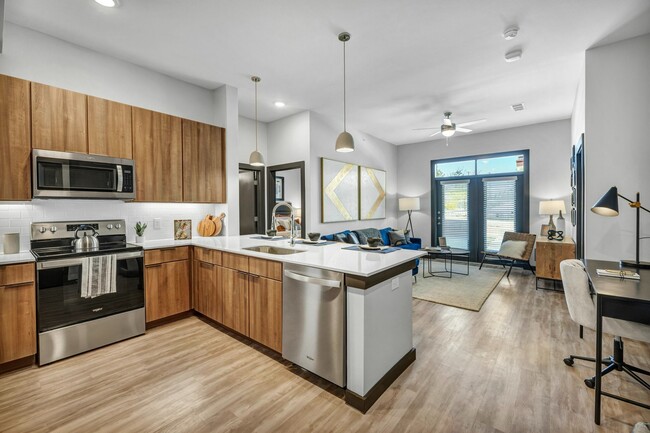 Saludado por la amplia cocina y sala de estar al entrar - The Brick and Mortar District Apartments