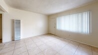 Located at 7746 Bright Ave in Whittier, CA, this single-story, one-bedroom, one-bathroom unit offers a practical and efficient layout across its single floor. Light-toned ceramic tile flows throughout the open living and dining areas, creating a cohesive and easy-to-maintain foundation. The living room is bright and airy, benefiting from natural light admitted through a large window dressed with vertical blinds, while a wall-mounted air conditioning unit ensures year-round comfort. The space opens directly into the dining area, which connects seamlessly to the galley-style kitchen. The kitchen is well-equipped with warm-toned wood cabinetry, granite-look countertops, a double stainless steel sink, and a gas range, with ample upper and lower cabinet storage. A hallway leads to the private bedroom, which features light wood-style laminate flooring, a generous window for natural light, and a closet with bi-fold panel doors. The bathroom has been tastefully updated with a white vessel sink vanity, a sleek rectangular mirror, and a tub-shower combination enclosed by a glass sliding door with gray subway tile surround. Two closets provide additional storage throughout the unit, rounding out this efficiently designed Whittier residence.