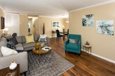 Located at 401 S Gallaher View Rd in Knoxville, TN, this single-floor residence offers a thoughtfully designed layout with a seamless flow between living, dining, and kitchen areas. The living room is a standout space, anchored by a bold teal accent wall, warm hardwood flooring, crown molding, and a textured ceiling. The open arrangement connects naturally to the dining area, which is brightened by a large sliding glass door that invites natural light and provides outdoor access, complemented by a pendant light fixture overhead.

The kitchen features dark cabinetry, granite countertops, and black appliances, with a convenient pass-through to the dining space. A dedicated in-unit laundry closet is tucked just off the kitchen for added practicality.

Both bedrooms are carpeted and generously sized, each offering closet space. The primary bedroom includes an en-suite bathroom and a walk-in closet, with soft blue accent wall tones creating a calm, restful atmosphere. The bathrooms are finished with granite vanity countertops, framed mirrors, and updated fixtures — one featuring a tub-shower combination.

Throughout the home, a cohesive neutral palette with teal and blue accents ties the spaces together, creating an inviting and well-balanced living environment.