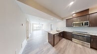 Located at 4805 W Genesee St in Syracuse, NY, this thoughtfully designed 2-bedroom, 2-bathroom unit offers a comfortable single-level layout with modern finishes throughout. Light gray hardwood-style flooring flows seamlessly across the open-concept living and kitchen areas, creating a cohesive and inviting atmosphere.

The kitchen is a standout feature, boasting rich dark brown shaker-style cabinetry, granite countertops, a herringbone tile backsplash, and a full suite of stainless steel appliances including a refrigerator, range, microwave, and dishwasher. A peninsula with additional counter space adds functionality and enhances the open feel connecting to the living area.

The spacious living room is bathed in natural light through large windows and a glass door that opens to the outside, complemented by a ceiling fan overhead. The generously sized primary bedroom offers ample space and is served by a well-appointed en-suite bathroom featuring a double granite-topped vanity with dark cabinetry, a tall linen tower, and tile flooring. The second bathroom provides a clean, functional design. A dedicated in-unit laundry room with a full-size washer and dryer adds everyday convenience. Neutral tones and clean lines throughout give this unit a fresh, modern ambiance.