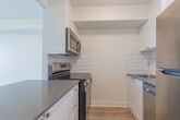 Located at 21 King St in downtown London, Ontario, this two-storey unit offers 2 bedrooms and 2 bathrooms across a well-organized layout. The main floor comprises the larger portion of the living space, while the upper level provides a more intimate, secondary area. Throughout the unit, light wood laminate flooring creates a warm, cohesive look that complements the crisp white walls and clean white baseboards.

The bedrooms are bright and functional. The primary bedroom features a window that invites natural light and offers outward views, a built-in sliding closet, and a wall-mounted heater, providing a comfortable and practical space. The second bedroom is similarly finished with light flooring and white walls.

The two bathrooms are distinctly styled. The main bathroom is well-appointed with classic white subway tile surrounding a full bathtub and shower, grey stone-look tile flooring, a white vanity with storage cabinetry, and a large mirror. The second bathroom is a compact, efficient space finished in all white, complete with a single-basin sink, chrome fixtures, and a mirrored medicine cabinet.

Hallways on both floors connect the rooms cleanly, maintaining the unit's consistent, minimalist aesthetic. The overall ambiance is bright, modern, and move-in ready, with a neutral palette that suits a wide range of interior styles.