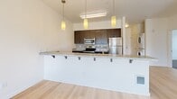 Located at 333 NE 146th Ave in Portland, Oregon, this 2-bedroom, 2-bathroom residence offers a thoughtfully designed single-level layout that maximizes functionality and comfort. The open-concept kitchen serves as a focal point, featuring dark espresso cabinetry, granite countertops, a peninsula breakfast bar with pendant lighting, and a full suite of stainless steel appliances. Light hardwood flooring flows throughout the main living and kitchen areas, creating a warm, cohesive aesthetic.

Both bedrooms are carpeted and bathed in natural light from large windows fitted with blinds, offering pleasant views of surrounding greenery. The primary bedroom includes a double-door closet and ample space for furnishings. The second bedroom also benefits from multiple windows framing lush outdoor tree views.

The two bathrooms are finished consistently with dark wood vanities, granite countertops, and light hardwood flooring. The primary bathroom features an extended vanity with generous counter space and a large mirror, while the second bathroom includes a full tub-shower combination. Clean white walls and neutral tones throughout create a bright, modern ambiance well-suited to a variety of interior styles.