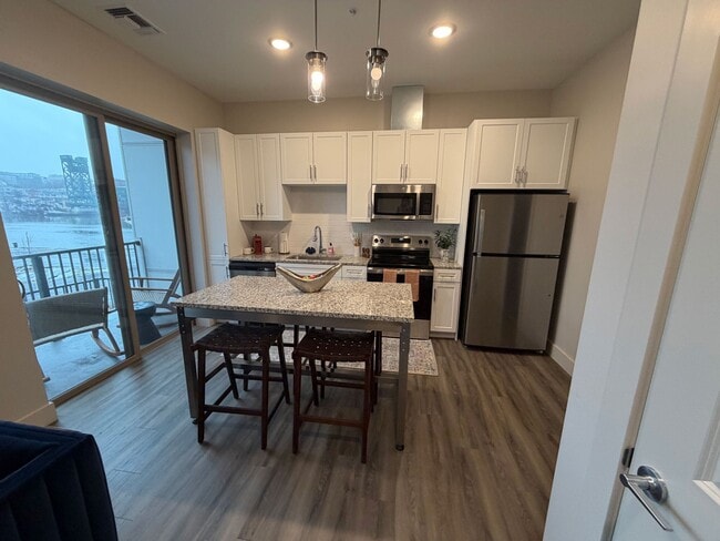 Modern kitchen and dining room with views of the river - Triton at the Flats Apartments