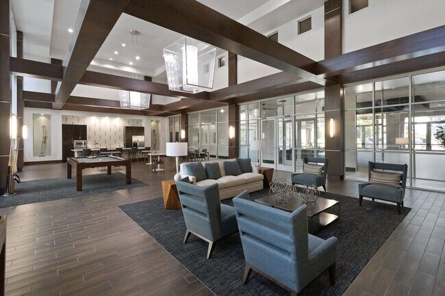 Amplia zona de estar con galería de TV ubicada en el salón de juegos para residentes - ICON at Ross