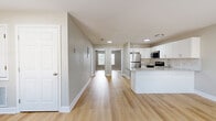 Located at 3422 W 7th St in Hattiesburg, Mississippi, this single-story 2-bedroom, 1-bathroom home offers a clean, modern interior with a cohesive and functional layout. Light-toned hardwood flooring runs throughout the entire home, lending warmth and visual continuity to every room.

The open-concept kitchen and living area serves as the heart of the home. The kitchen is outfitted with white shaker-style cabinetry, a marble-look tile backsplash, granite countertops, and a peninsula that provides additional prep and seating space. Stainless steel appliances — including a refrigerator, range, and built-in microwave — complete the modern kitchen setup. Recessed lighting illuminates the space efficiently.

Both bedrooms are comfortably sized, featuring ceiling fans, natural light from windows with blinds, and ample closet space. The neutral gray walls and light hardwood floors give each room a calm, versatile atmosphere. The primary bedroom offers a generous footprint with access to closets and the hallway.

The full bathroom is neatly finished with a white vanity, a framed mirror, a bathtub/shower combination, and consistent hardwood-style flooring. The overall design throughout the home is clean and move-in ready, with neutral tones and modern fixtures that appeal to a wide range of preferences.