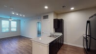 Located in San Antonio, TX 78204, this 2-bedroom, 2-bathroom residence is thoughtfully laid out across a single floor. The open-concept kitchen serves as the heart of the home, featuring a peninsula with granite-look countertops and a double-basin sink, dark espresso cabinetry, black appliances including a refrigerator, range, and microwave, and recessed lighting overhead. Wood-look flooring flows throughout the main living areas, creating a warm and cohesive aesthetic. The living area is bright and open, with track lighting and easy access to the rest of the unit. Both bedrooms are carpeted for comfort and equipped with ceiling fans and window blinds that allow for natural light and privacy. One bedroom features dual windows and a walk-in closet with wire shelving. Each of the two bathrooms includes a single-sink vanity with dark cabinetry, a tub-shower combo, wood-look flooring, and a large mirror. The primary bathroom also connects to a walk-in closet with wire rack shelving. Clean neutral wall tones throughout the unit complement the contemporary finishes, creating a cohesive and move-in-ready living environment.