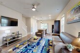 Located at 2327 Erie Dr in Ann Arbor, Michigan, this three-story home offers five bedrooms and five bathrooms thoughtfully distributed across all floors. The entry level provides a welcoming entrance and staircase access to the main living areas above.

The main floor serves as the heart of the home, featuring an open-concept layout that connects the living room and kitchen seamlessly. The living room is bright and inviting, with recessed lighting, a ceiling fan, and multiple windows that allow natural light to fill the space. The modern kitchen is a standout, boasting dark espresso cabinetry, stainless steel appliances, granite countertops, and a generous island with bar seating for six — ideal for entertaining. Pendant lighting above the island adds a stylish finishing touch. A balcony extends from this level, providing outdoor access and views.

The upper floor houses the bedrooms, each carpeted and equipped with ceiling fans and closets. The bathrooms are well-appointed with granite vanity tops, dark wood cabinetry, and tub-shower combinations. With six closets spread throughout the home, storage is abundant. The neutral color palette, light hardwood-style flooring on the main level, and consistent modern finishes create a cohesive and comfortable ambiance throughout.