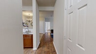 This single-floor, two-bedroom, two-bathroom residence offers a thoughtfully designed layout that balances comfort and functionality. The living room serves as the heart of the home, featuring hardwood flooring, a ceiling fan, and French doors that invite natural light and outdoor views. The open flow connects seamlessly to the dining area, which is highlighted by an elegant chandelier overhead and tile flooring, creating a welcoming space for meals and entertaining.

The kitchen features warm wood cabinetry paired with light stone-look countertops and hardwood-style flooring, providing ample storage and workspace. The primary bedroom is generously sized, finished with plush carpet, a ceiling fan, and a large window that frames outdoor views. It is complemented by a spacious walk-in closet outfitted with wire shelving and hanging rods. The second bedroom also features carpet flooring and dual windows with drape treatments, offering a bright, restful retreat.

Both bathrooms are well-appointed; one features a tub-shower combination with built-in tiled shelving, while the other includes a wide vanity with stone-look countertops, white cabinetry, and wood flooring. The overall ambiance is neutral, clean, and move-in ready.