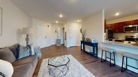 Located at 198 Littleton Road in Chelmsford, MA, this single-floor residence offers a well-considered layout designed for comfortable everyday living. The open entryway welcomes you with rich hardwood-style flooring that flows throughout the main living areas, providing a warm and cohesive aesthetic. The living room is a comfortable gathering space, featuring neutral walls and recessed lighting that creates an inviting ambiance. Adjacent to it, the dining area is brightened by a large window framing views of the natural surroundings outside — an ideal spot for meals and conversation. The kitchen is equipped with rich dark cabinetry, granite-style countertops, stainless steel appliances including a range, microwave, refrigerator, and dishwasher, all set against light hardwood-style flooring. Multiple bedrooms offer plush carpeting, natural light from well-placed windows, and a serene, restful atmosphere. The bathrooms are finished with dark wood vanities, white countertops, and clean tilework, with one featuring a tub-shower combination. Throughout the space, consistent finishes and a neutral color palette create a unified, move-in-ready environment well-suited to a variety of lifestyles.