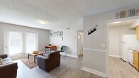 Located at 3528 Gentian Blvd in Columbus, Georgia, this single-story, 2-bedroom, 3-bathroom home offers a practical and comfortable layout across its single floor. Light gray walls, wood-look flooring, and textured ceilings create a consistent, neutral aesthetic throughout the space.

The living room serves as the heart of the home, featuring a set of French doors that invite natural light and provide outdoor access. Adjacent to it, the dedicated dining room is accented with a chair-rail molding detail along the walls, lending a subtle architectural touch.

The galley-style kitchen is equipped with warm honey-toned wood cabinetry, granite-look countertops, and white appliances including a refrigerator and dishwasher, with direct access to a utility area.

The primary bedroom offers a walk-in closet and connects to one of the three bathrooms. The second bedroom includes a ceiling fan, multiple windows for natural light, and ample floor space. Each bathroom features wood vanities with granite-look countertops, large mirrors, and wood-look flooring.

Additional highlights include a dedicated laundry area, a hallway connecting the main rooms efficiently, and three closets distributed throughout the home for generous storage. The overall design is clean, functional, and move-in ready.
