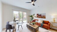 Located at 1401 Tower Grove Ave in St. Louis, MO, this two-story residence offers a well-designed layout split evenly across two floors. The main level features an open-concept kitchen and living area, highlighted by light hardwood floors throughout. The kitchen is outfitted with white shaker cabinetry, black hardware accents, stainless steel appliances, a central island with bar seating, and recessed lighting — a highly functional and stylish space. The adjacent living room is bright and welcoming, featuring large sliding glass doors that open to a private outdoor balcony, filling the space with natural light and providing outdoor views. Three bathrooms serve the residence, including one with a classic subway-tiled tub-shower combo with chrome fixtures, and another featuring a sleek walk-in shower with a matte black-framed glass door and white tile surround. The upper floor houses the primary bedroom, a generously sized retreat with a ceiling fan, a large window overlooking greenery, light hardwood flooring, and access to an additional balcony via sliding glass doors. Multiple hallways connect the rooms across both levels, providing a logical and accessible flow throughout. The overall aesthetic is clean, contemporary, and filled with natural light.