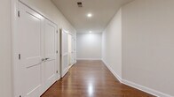 Located at 339 W Broad St in Westfield, NJ, this single-floor home offers four bedrooms, two bathrooms, and a well-organized layout designed for comfortable living. The interior is characterized by rich hardwood flooring that flows throughout the main living areas and bedrooms, complemented by crisp white walls and recessed lighting that create a clean, bright ambiance.

The combined kitchen and living room area serves as the heart of the home. The kitchen is outfitted with white shaker-style cabinetry, grey countertops, a stylish tile backsplash, and a full suite of stainless steel appliances including a gas range, microwave, and refrigerator. Light tile flooring grounds the kitchen space.

The living area benefits from natural light streaming through arched windows, lending an elegant architectural detail to an otherwise clean-lined, modern interior. The generously sized primary bedroom continues the hardwood flooring and includes a window with natural light.

A wide hallway connects the bedrooms, featuring multiple white panel doors, louvered closet doors for convenient storage access, and recessed ceiling lights. Both bathrooms are finished with neutral tile flooring, and one features a tub-shower combination with marble-style tile surround, a white vanity, and dark countertop. The home also includes a dedicated closet, adding to its practical storage solutions.