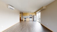 Located at 1450 N Prescott St in Portland, Oregon, this well-appointed two-bedroom, two-bathroom residence offers a thoughtfully designed single-level layout. The open-concept kitchen and living area serves as the heart of the home, featuring wood-style flooring, neutral walls, and a wall-mounted mini-split unit for year-round climate control. The kitchen is equipped with stainless steel appliances — including a refrigerator, electric range, built-in microwave, and dishwasher — complemented by light maple cabinetry, track lighting, and a large floor-to-ceiling window that fills the space with natural light and provides views of the surrounding Portland neighborhood. The spacious primary bedroom offers a generous footprint with a sliding-door closet, while the second bedroom mirrors a similarly clean, functional design. Both bedrooms feature wood-style flooring and recessed ceiling light fixtures. A carpeted hallway connects the private areas of the home, leading to a dedicated walk-in closet with wire shelving. The two bathrooms are finished with light wood vanity cabinetry, stone-look countertops, and a full tub-shower combination. Throughout the residence, light-toned trim, warm neutral walls, and light maple door frames create a cohesive, modern aesthetic.